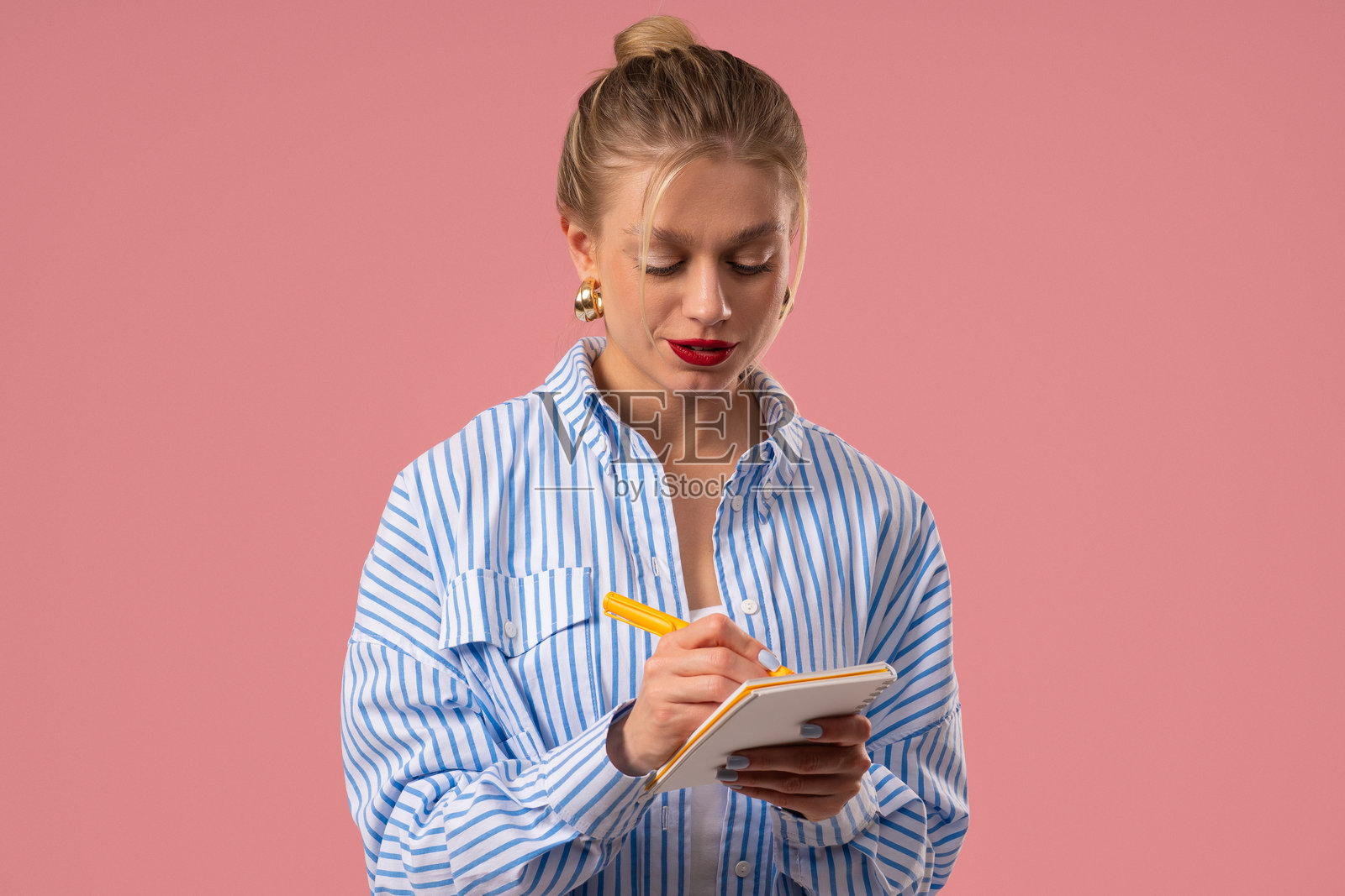 年轻女子用笔在计划本上写笔记，漂亮的女孩在思考未来照片摄影图片