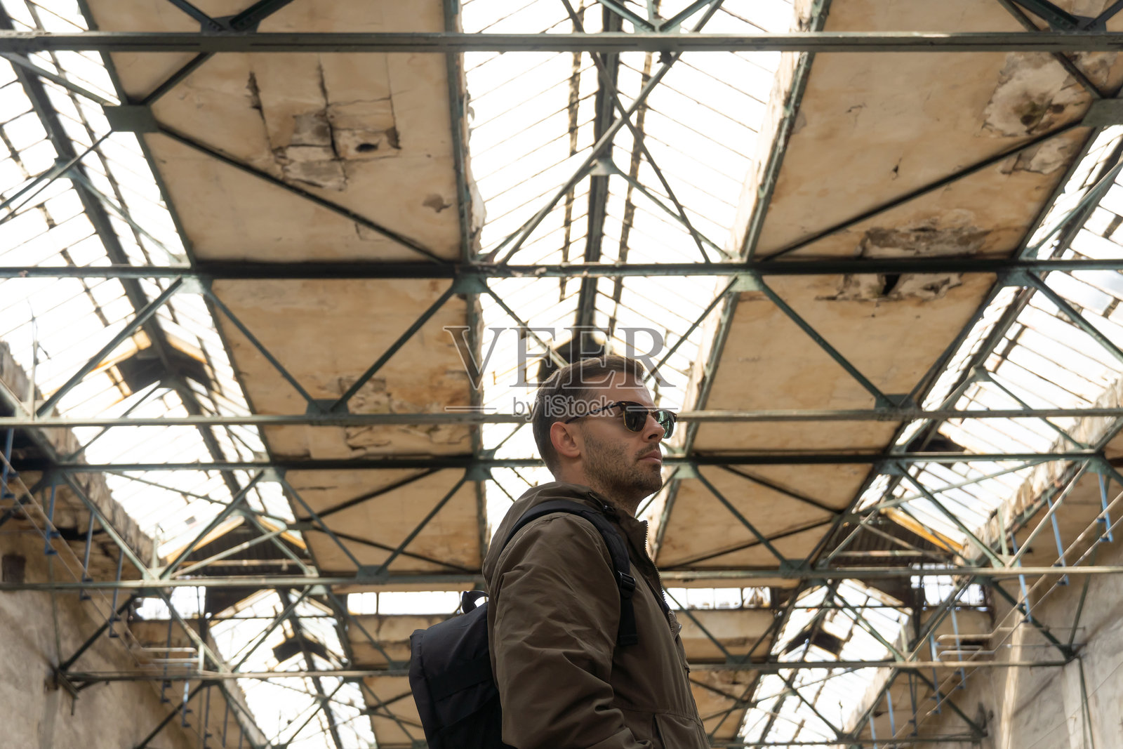 男人站在废弃的旧工厂大厅里照片摄影图片