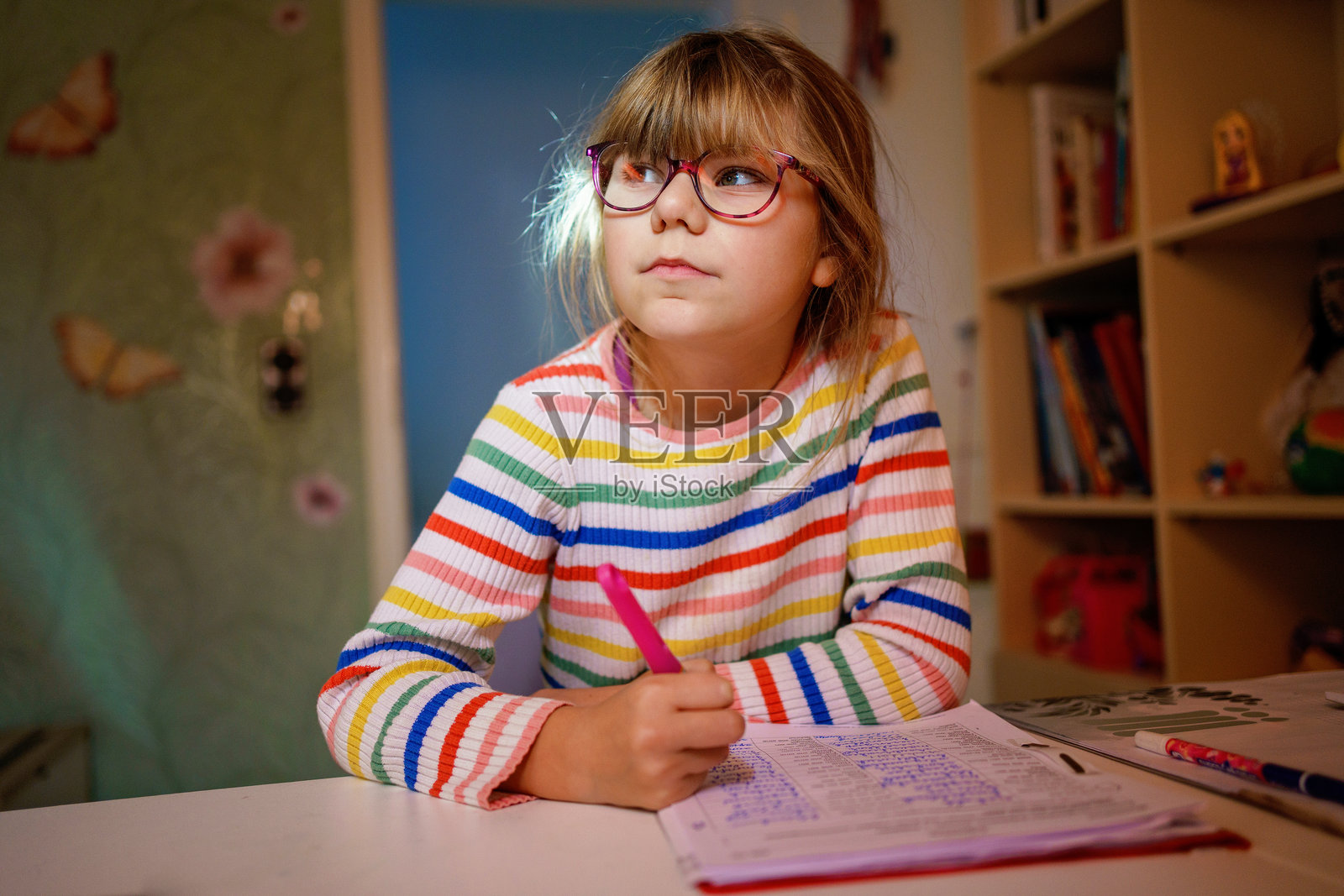 小女孩在房间里做作业，一个沮丧的孩子。照片摄影图片