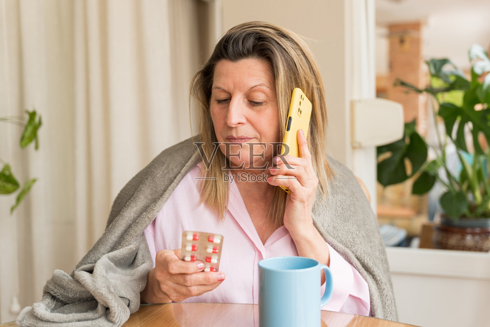 一位成熟的成年女性正在通过电话咨询医生关于药物的问题照片摄影图片