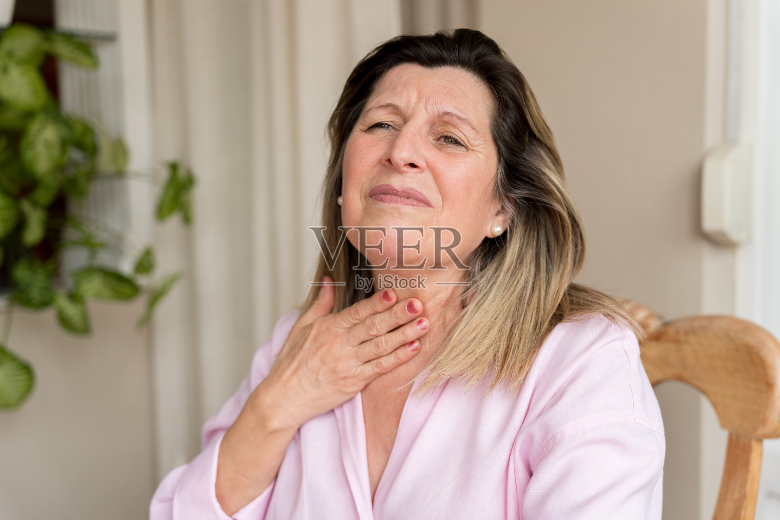 一位成熟的成年女性喉咙痛且吞咽困难照片摄影图片