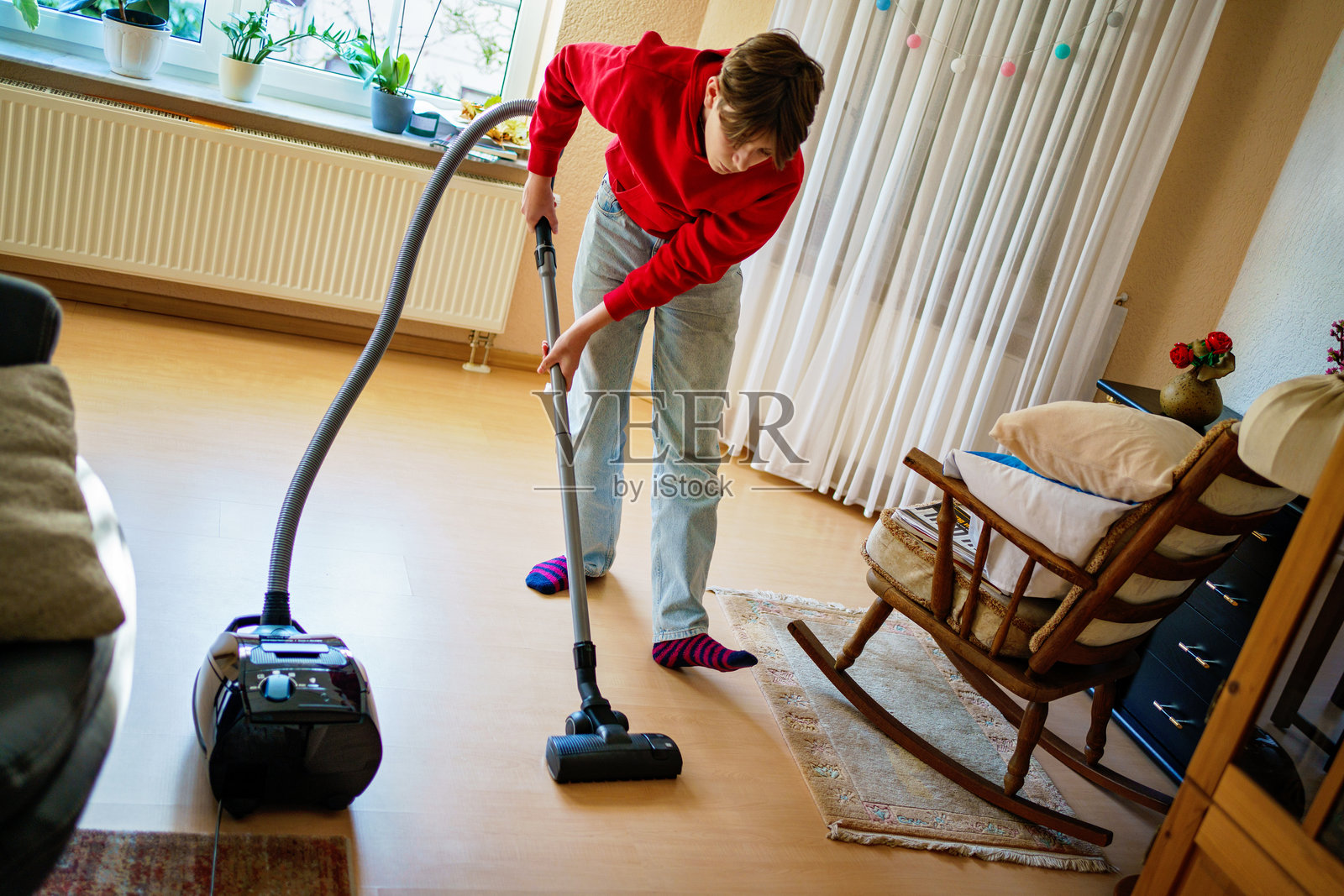 青少年男孩在家中打扫灰尘。少年儿童帮忙做家务。照片摄影图片