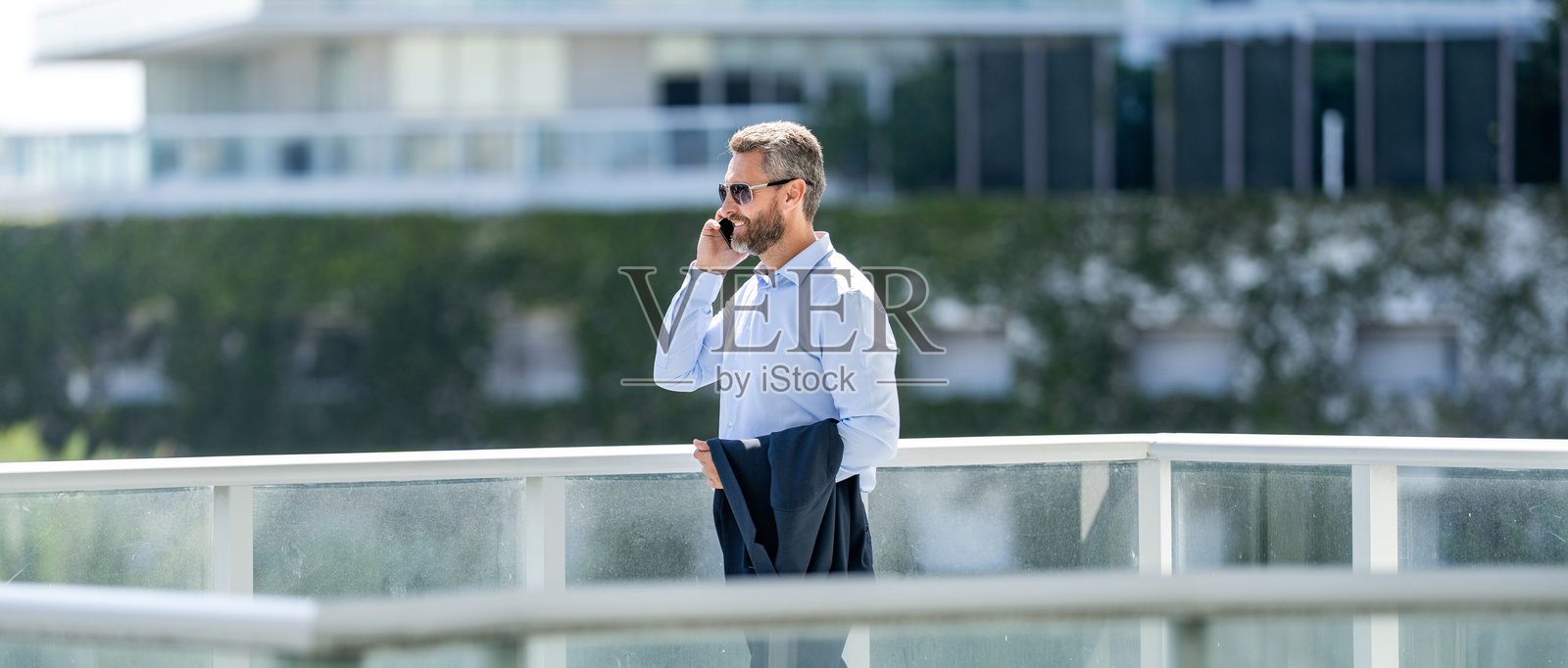 商人打电话。男子电话交谈。西班牙裔商人使用智能手机。商务沟通。男子回复电话。富有的商人户外讲电话。自信的姿势照片摄影图片