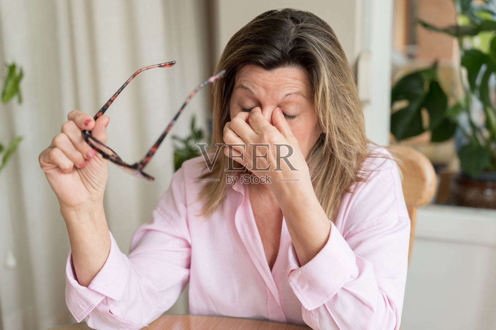 中年女性头痛，揉着疲惫的眼睛照片摄影图片