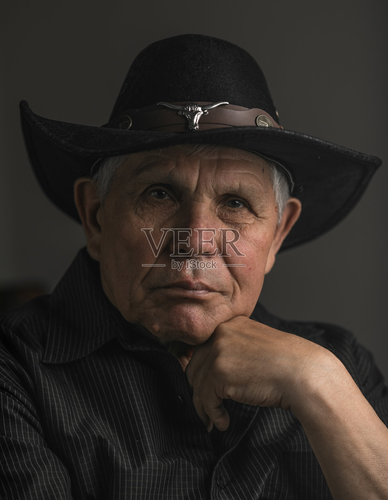 一位戴着牛仔帽、向上看的长者肖像照片摄影图片