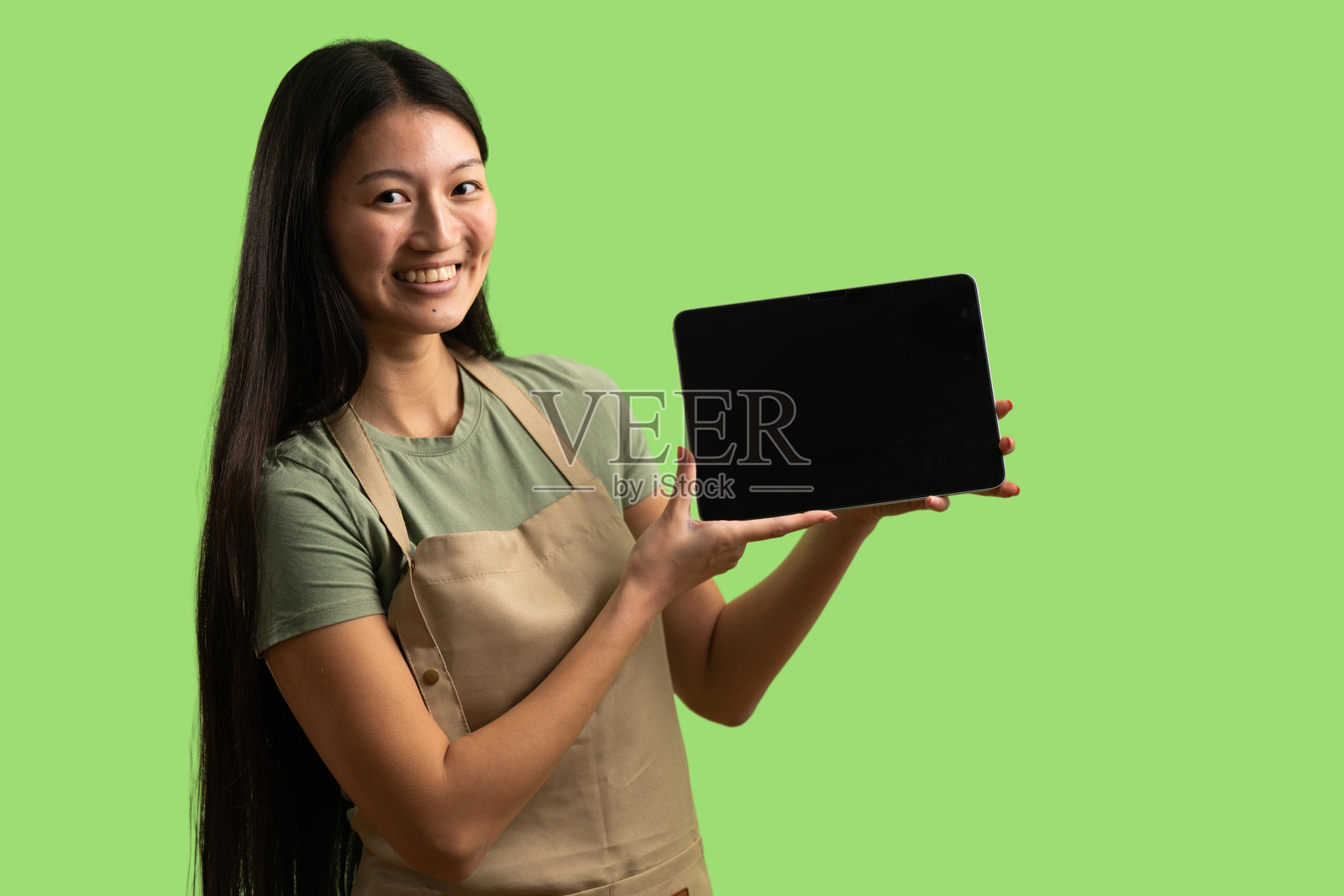 年轻女子展示空白的数码平板电脑屏幕照片摄影图片