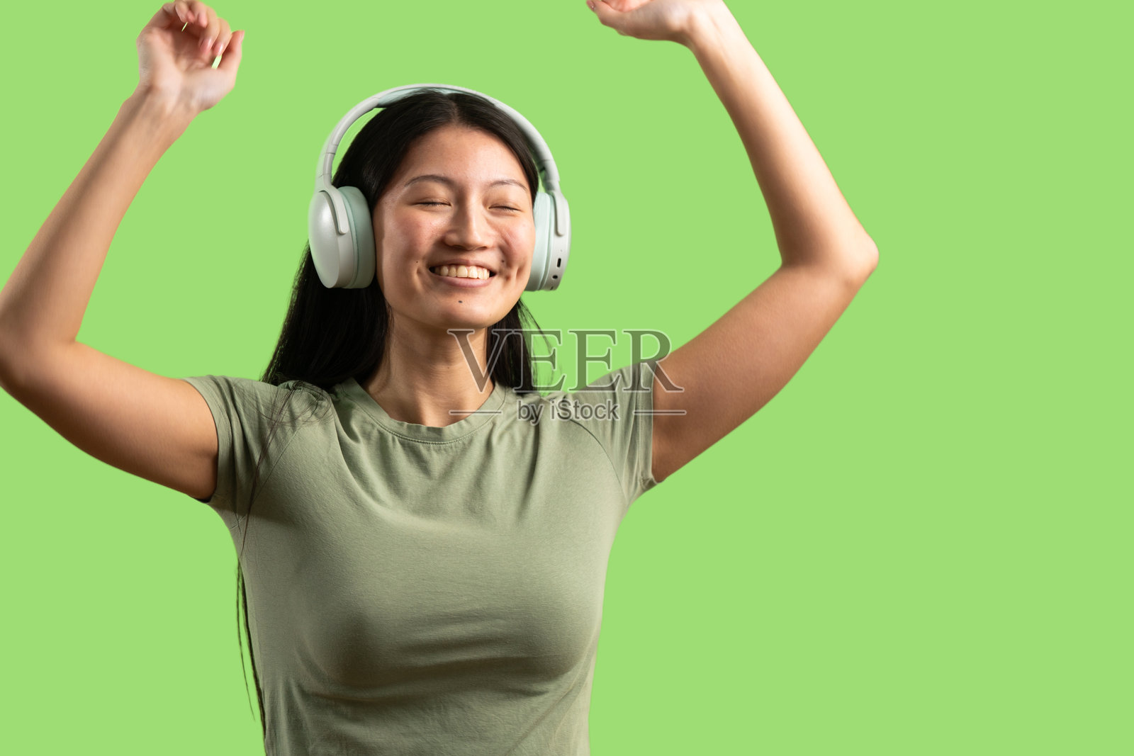 戴着耳机快乐跳舞的年轻亚洲女性照片摄影图片