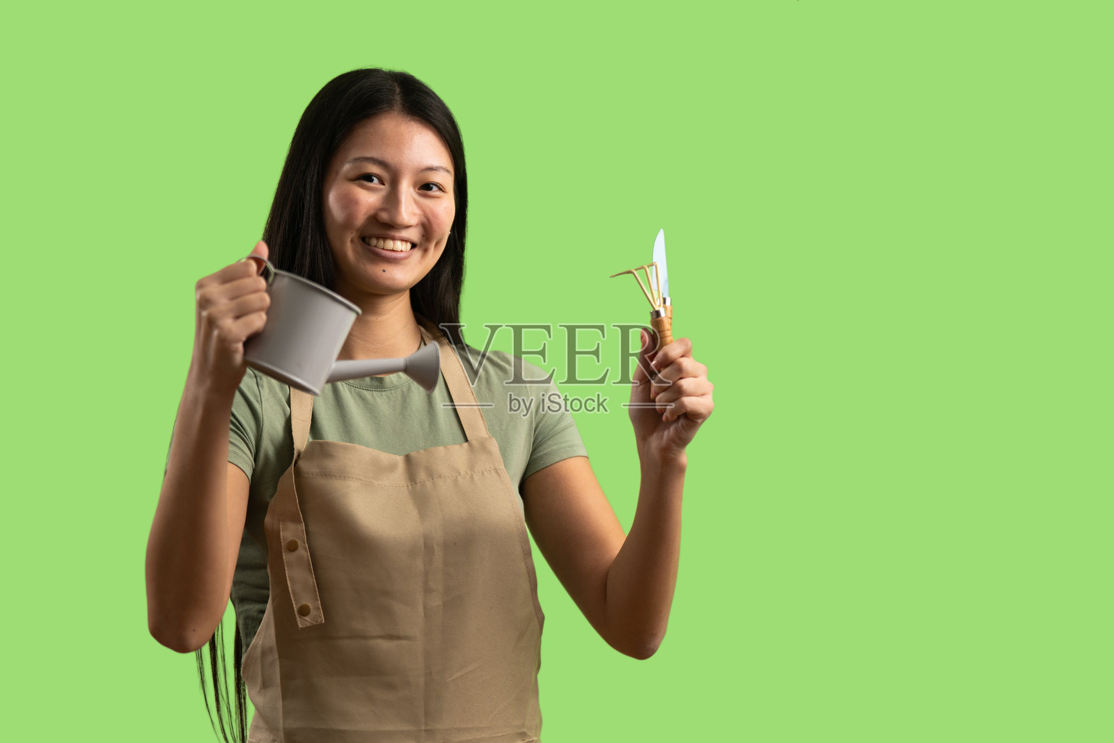 微笑的年轻亚洲女性，手持园艺工具照片摄影图片