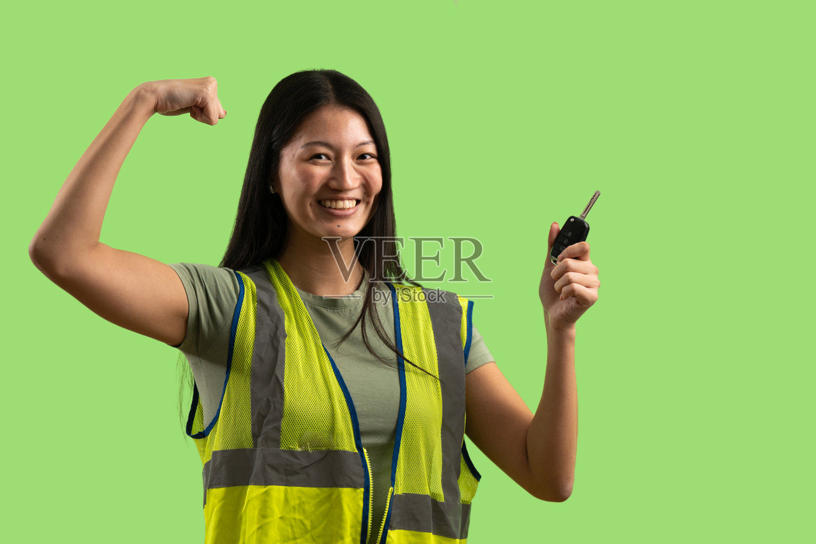 女工展示力量和车钥匙照片摄影图片