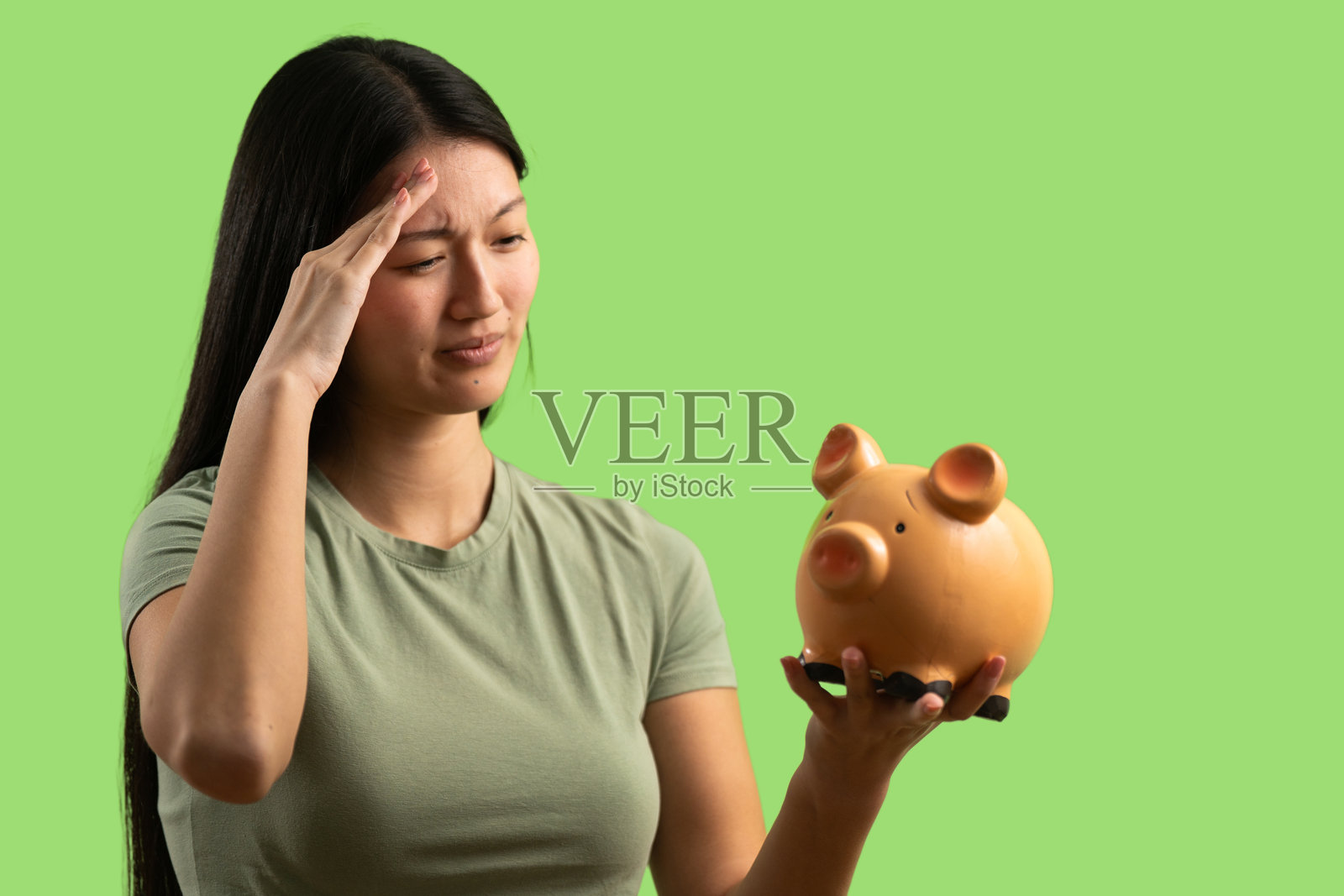 一位压力山大的女性，手里拿着空空的储蓄罐，感受到经济压力照片摄影图片