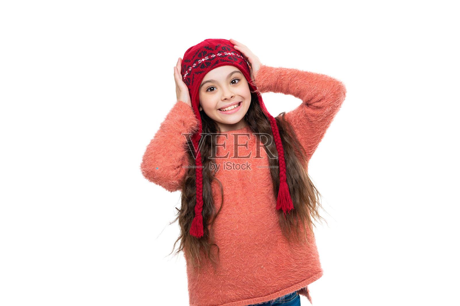 戴着冬季帽子、穿着针织毛衣的时尚女孩。快乐童年，白色背景隔离的少女肖像。少女冬季时尚风格。照片摄影图片