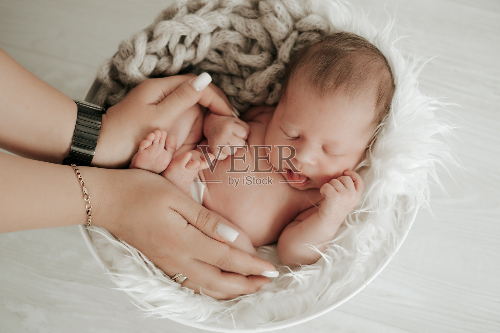 一个新生儿安详地睡在父母的怀抱里，这个场景为文字留有空间照片摄影图片