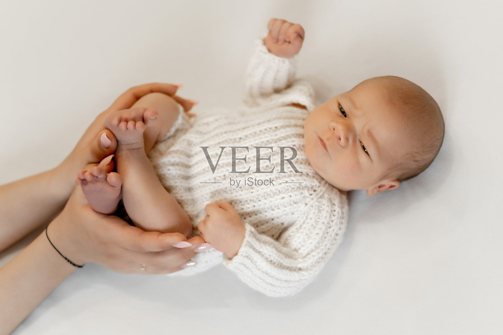 新生儿的肖像，白色孤立背景，安详地睡在母亲的怀里，熟睡的婴儿，留有文字空间照片摄影图片