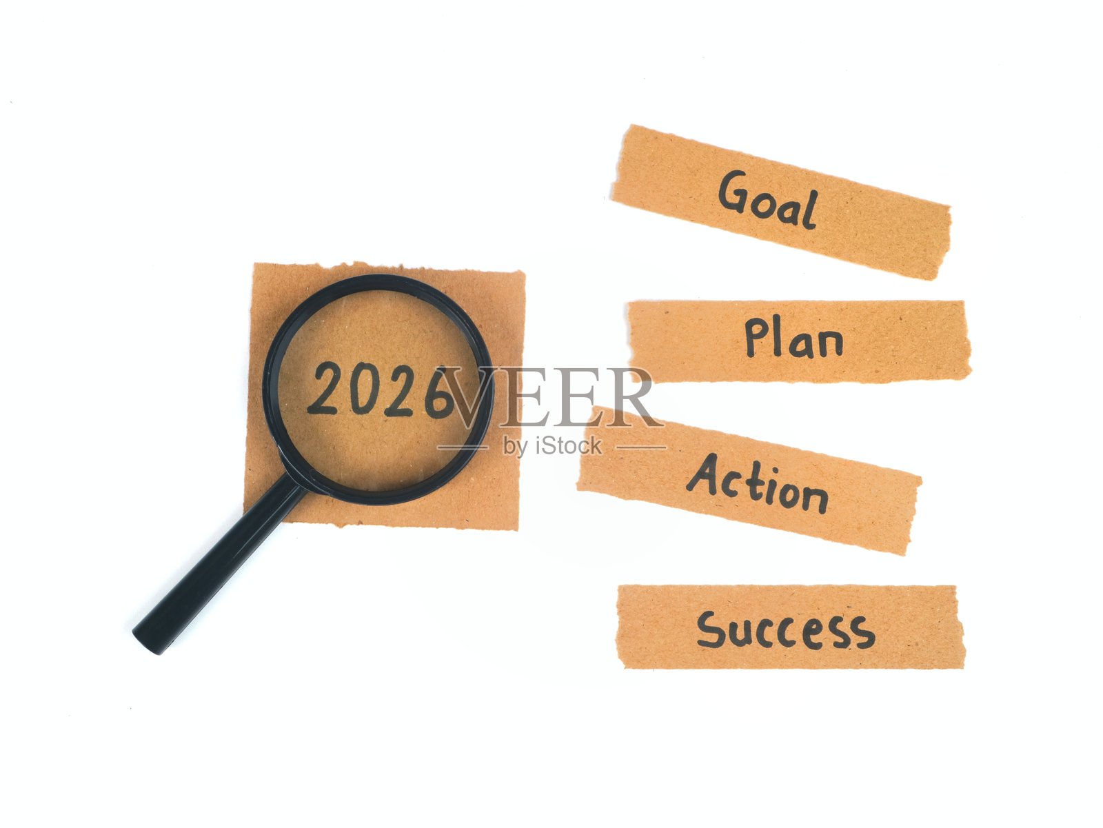 新年决心概念 2026。目标、计划、行动和成功写在撕碎的棕色纸上，旁边放着放大镜照片摄影图片