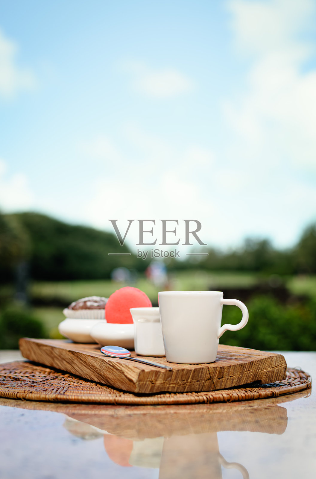 咖啡茶点托盘，配有马卡龙、松饼和意式浓缩咖啡，俯瞰高尔夫球场照片摄影图片