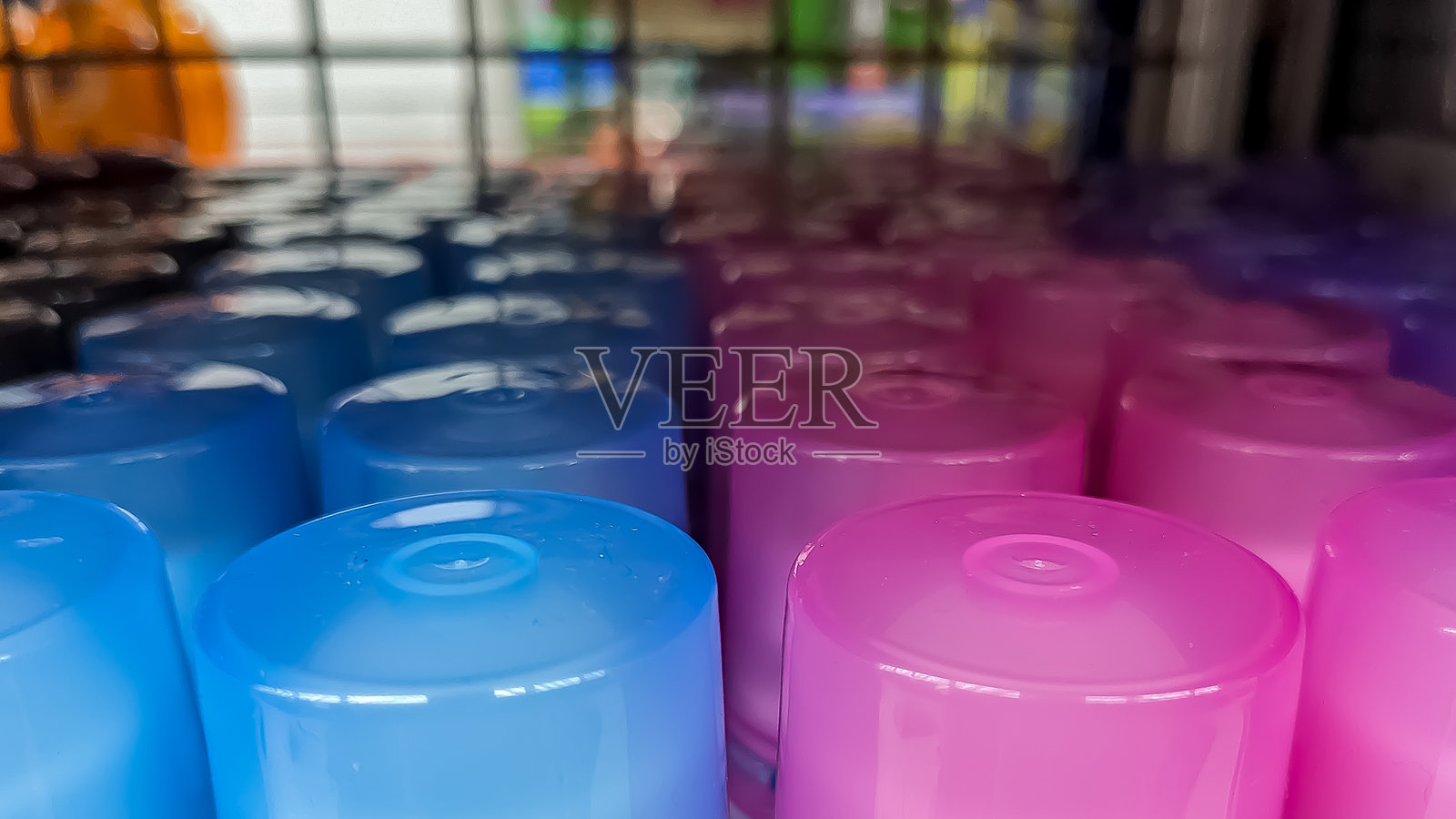 特写镜头下，色彩鲜艳的塑料瓶盖以蓝色和粉色为主色调，表面光滑，呈规律性排列。照片摄影图片