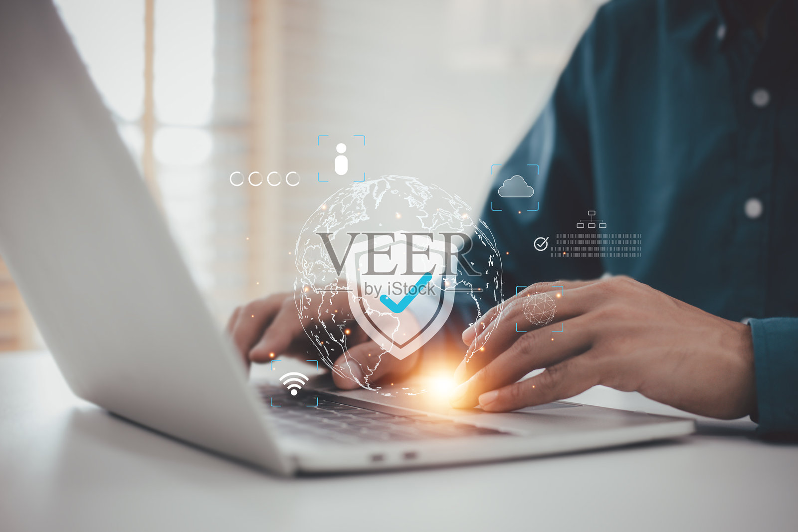 数字安全与全球网络防护：男子使用带有盾牌图标的笔记本电脑，象征网络安全和数据隐私照片摄影图片