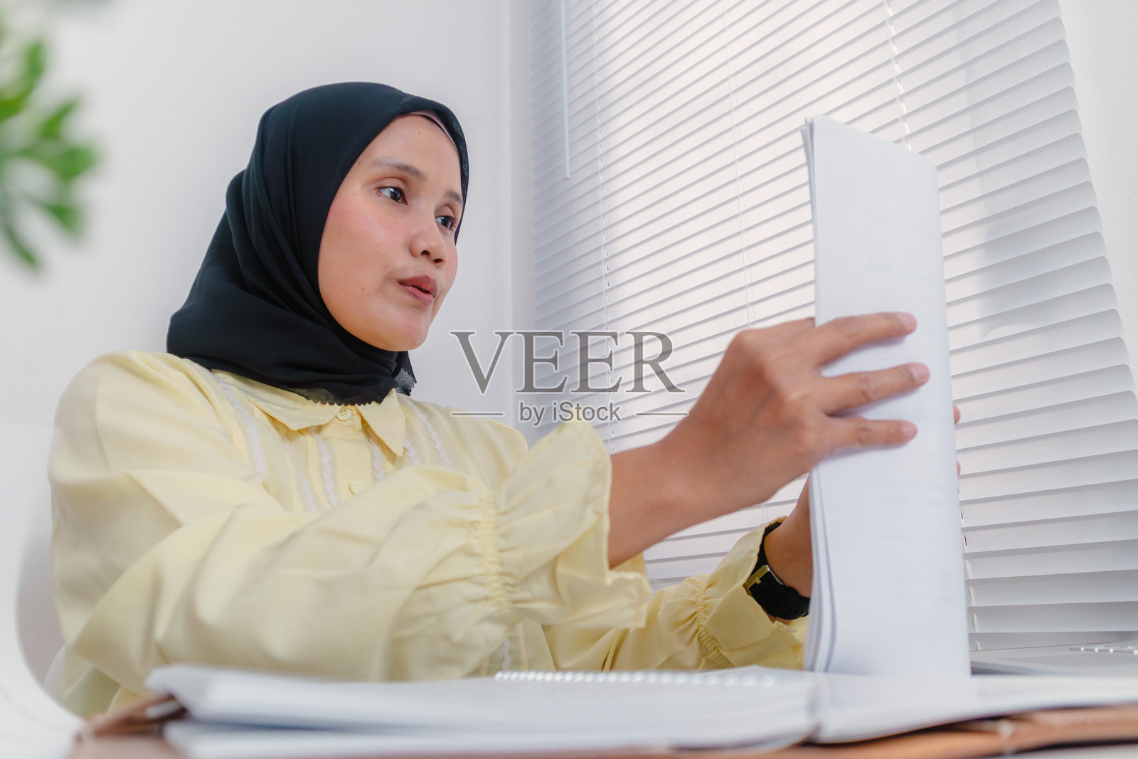 一位年轻的亚洲穆斯林女商人正在办公桌上整理文件照片摄影图片