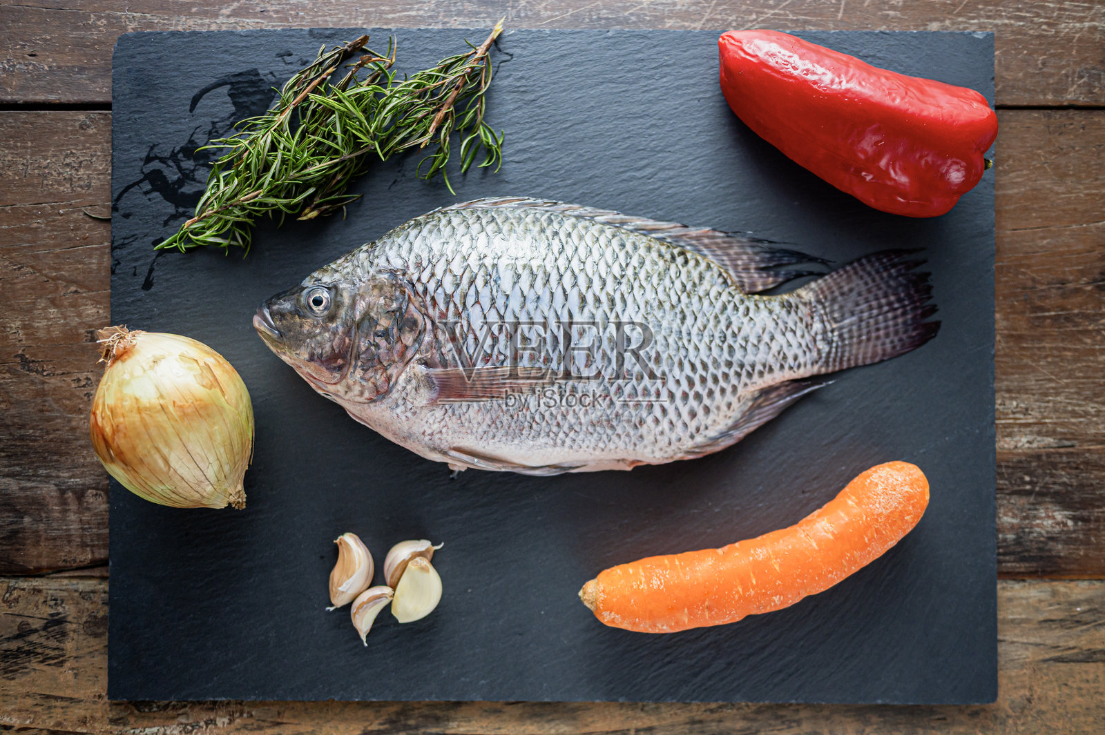 新鲜的莫哈拉鱼，准备在石板上与蔬菜和香草一起烹饪照片摄影图片