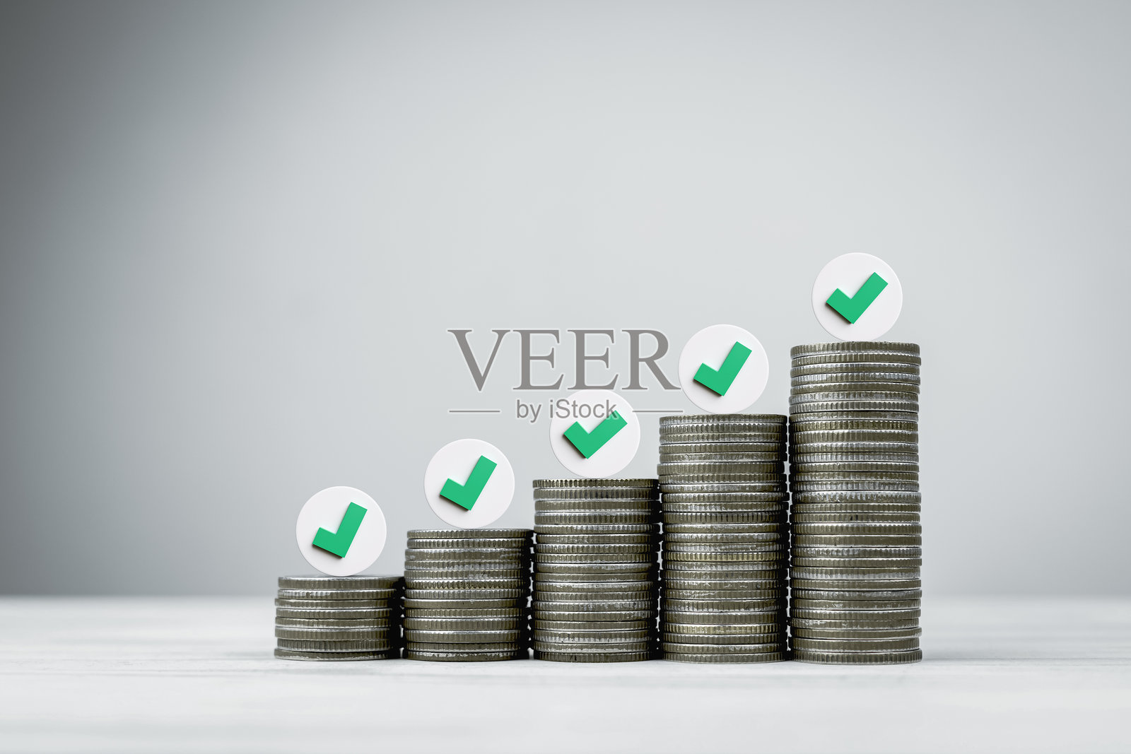 硬币堆上的勾号符号，象征着财务规划成功达成照片摄影图片