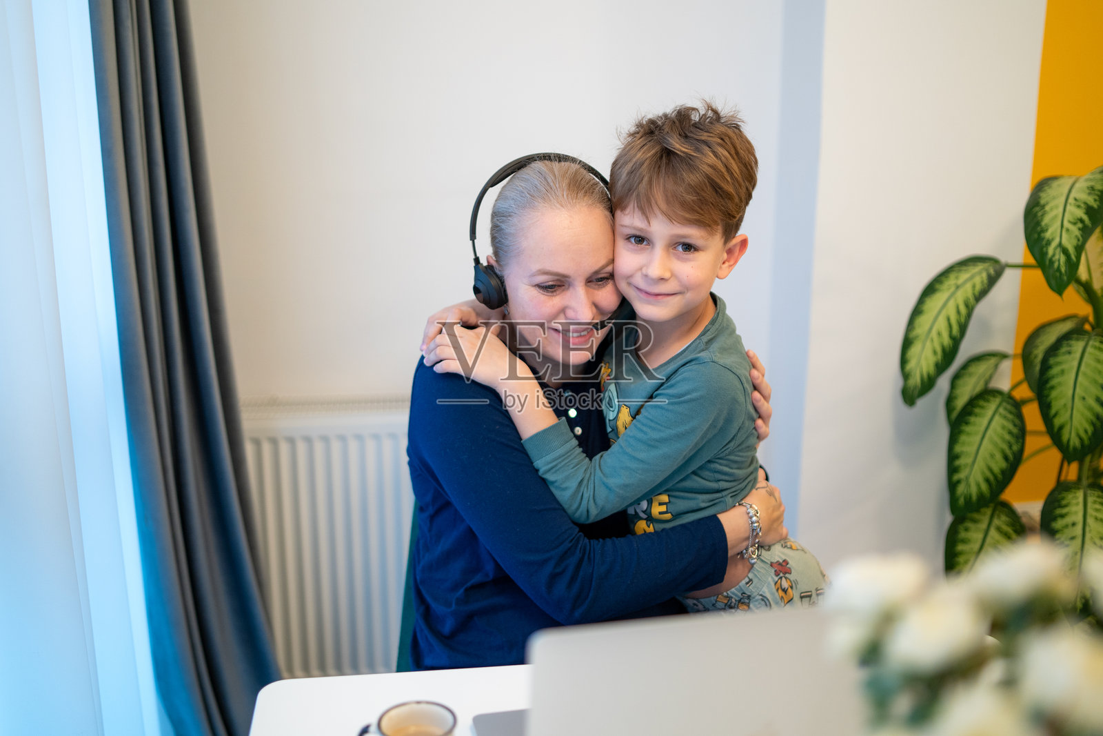 母亲和儿子在家视频通话时一起挥手照片摄影图片