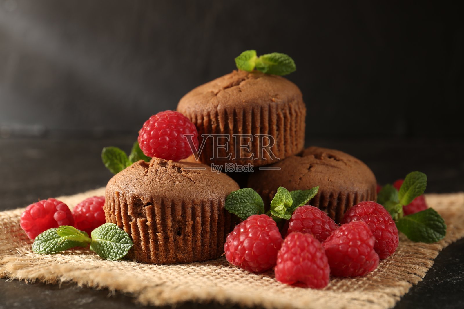 深色纹理桌面上摆放着美味的覆盆子薄荷玛芬，特写镜头照片摄影图片