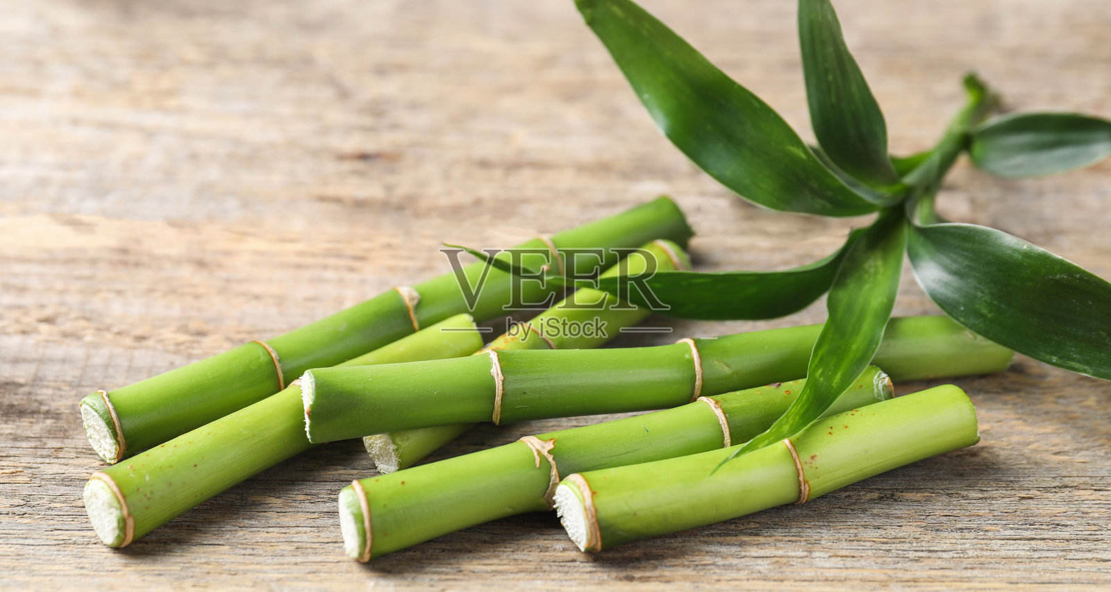 特写镜头下，木桌上的竹子茎叶被切割照片摄影图片