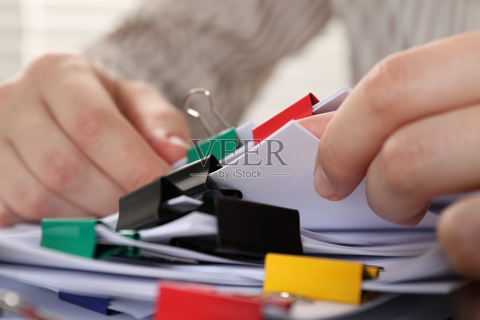 女子手持带有金属夹子的纸张，特写照片摄影图片