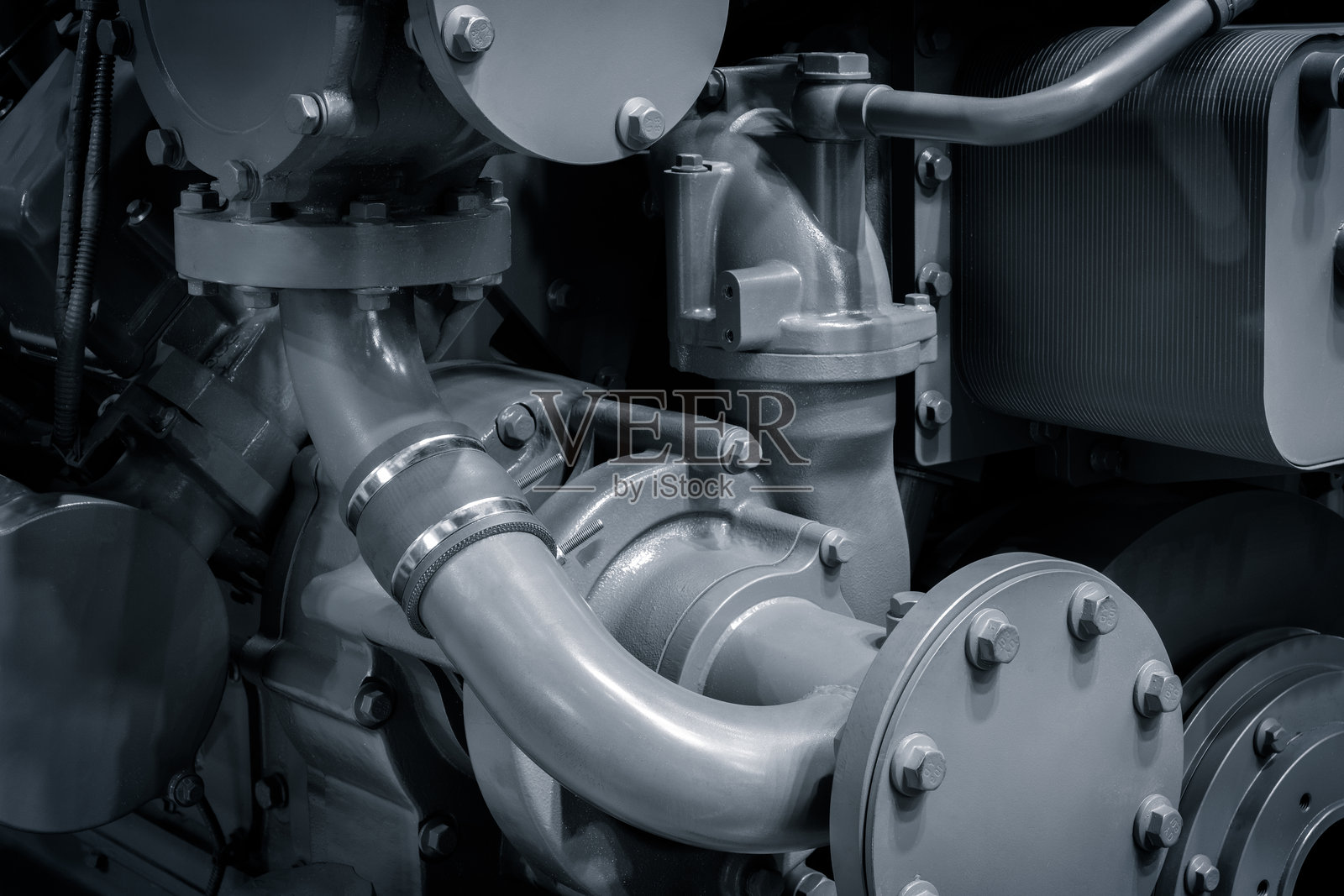 一个由许多零件组成的大型发动机，由金属制成，有许多管道和阀门。象征工业化和机器的复杂性。照片摄影图片