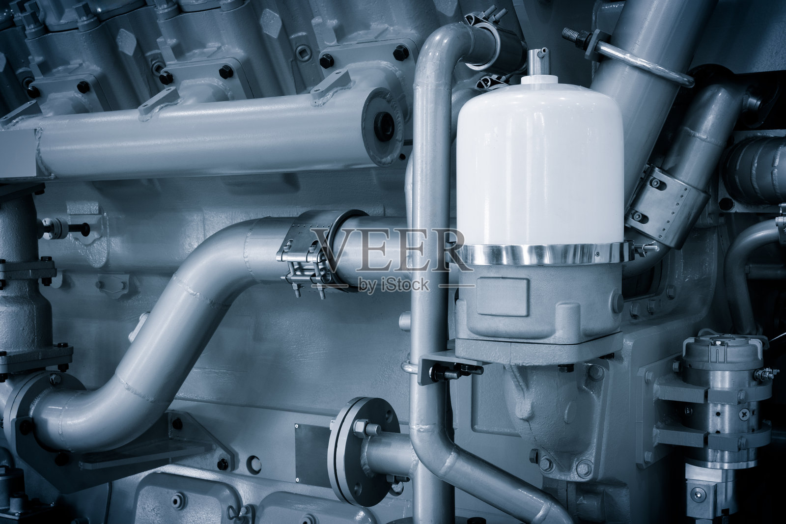 大型活塞燃气发动机发电机，带有许多阀门和管道。发动机是橙色的，有很多阀门。照片摄影图片