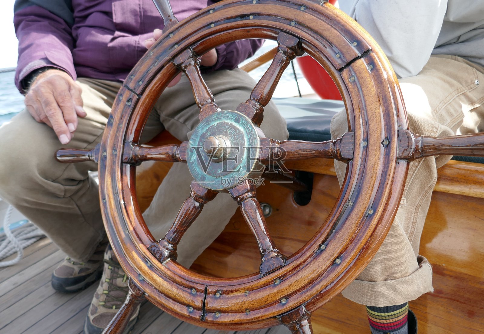 船舵，一位看不清面容的船长正坐着照片摄影图片