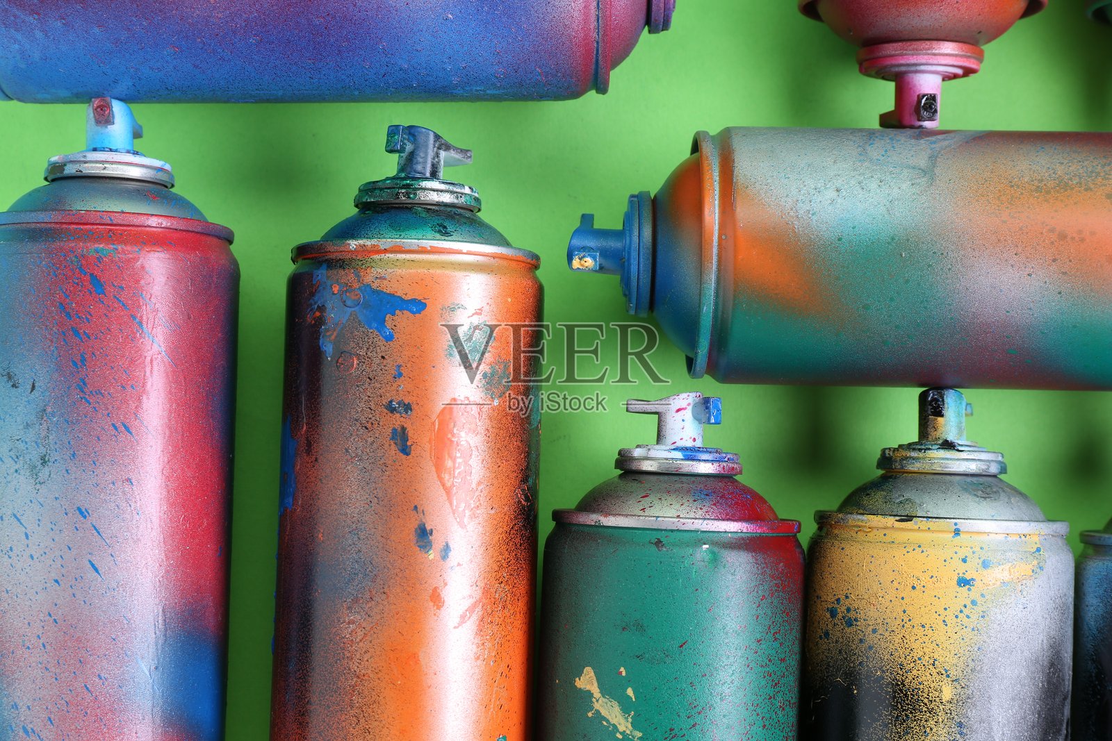 绿色背景上的喷漆罐，俯视角度照片摄影图片