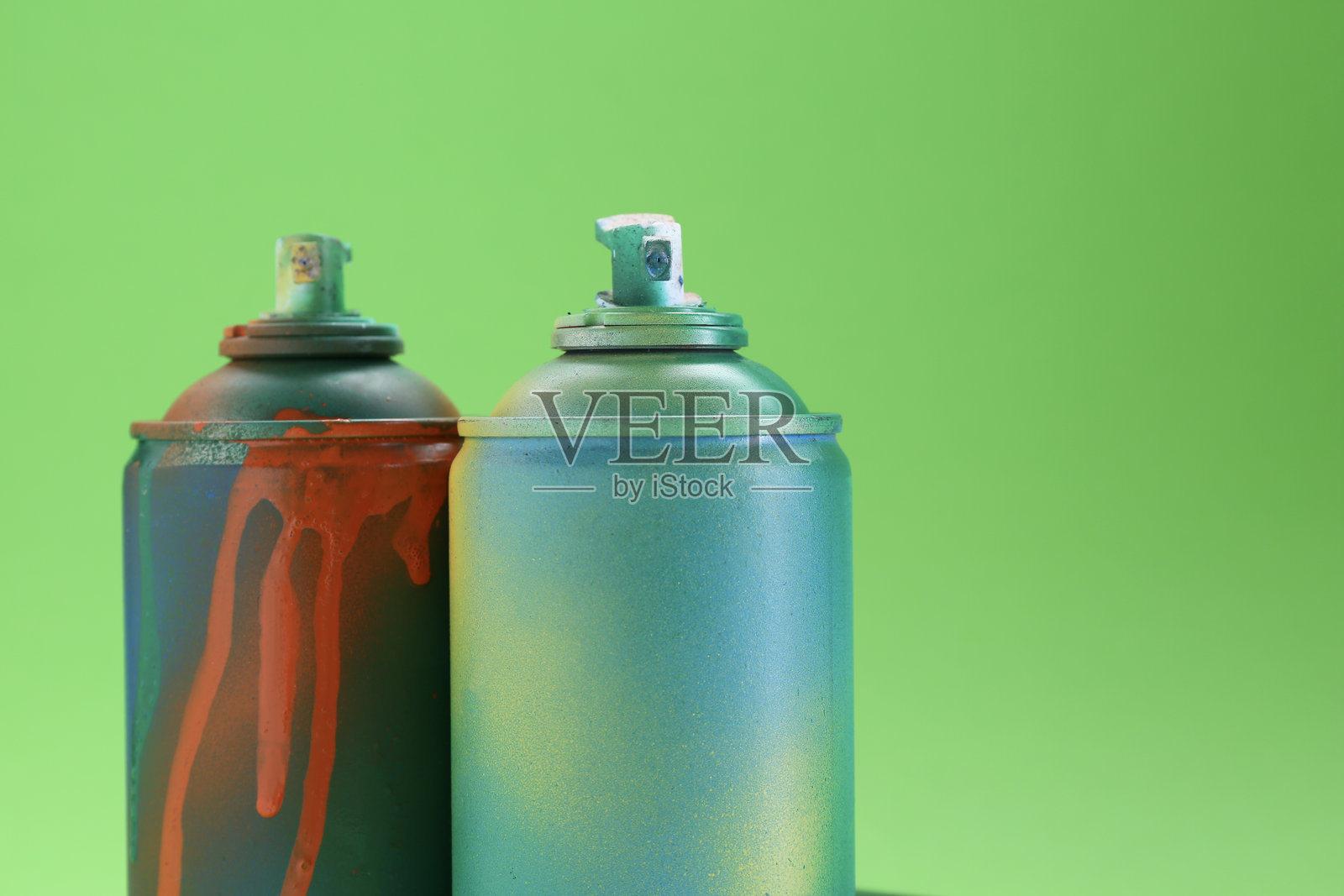 近距离特写，绿色背景上的明亮喷漆罐照片摄影图片