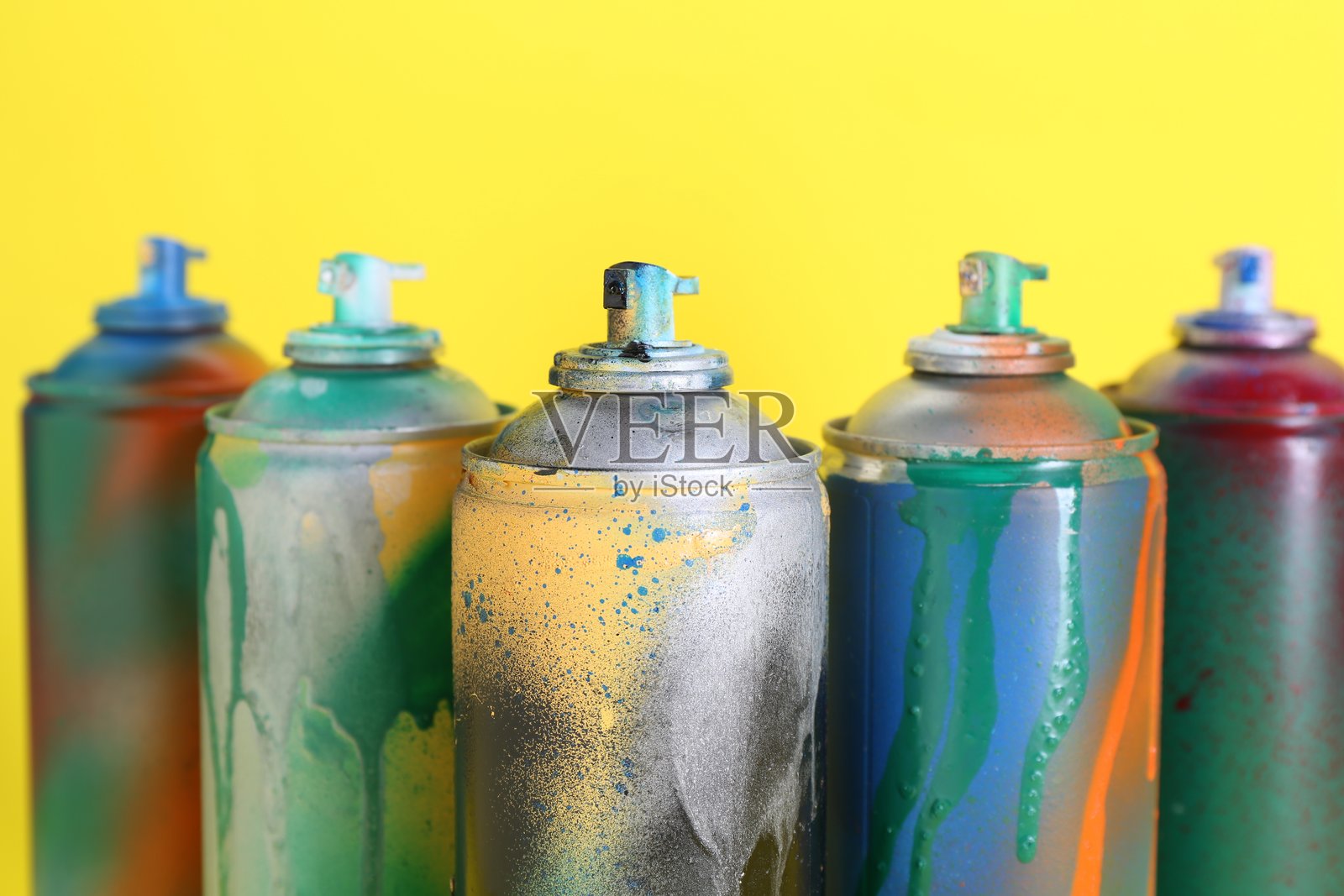 黄色背景下的喷漆罐特写照片摄影图片