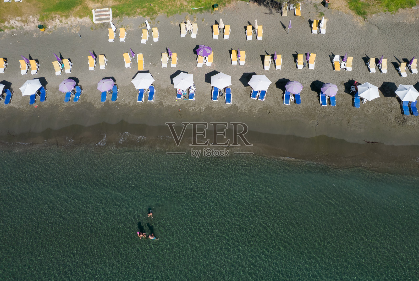 无人机航拍，俯瞰有遮阳伞和游泳人群的海滩。塞浦路斯总督海滩照片摄影图片