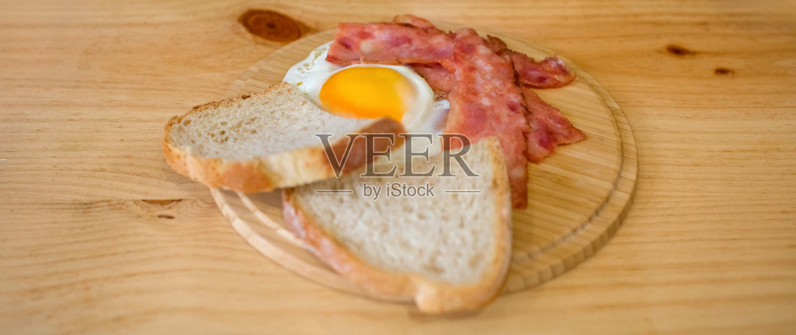 早餐套餐，包含煎蛋、培根、面包和卡布奇诺。快餐概念。照片摄影图片