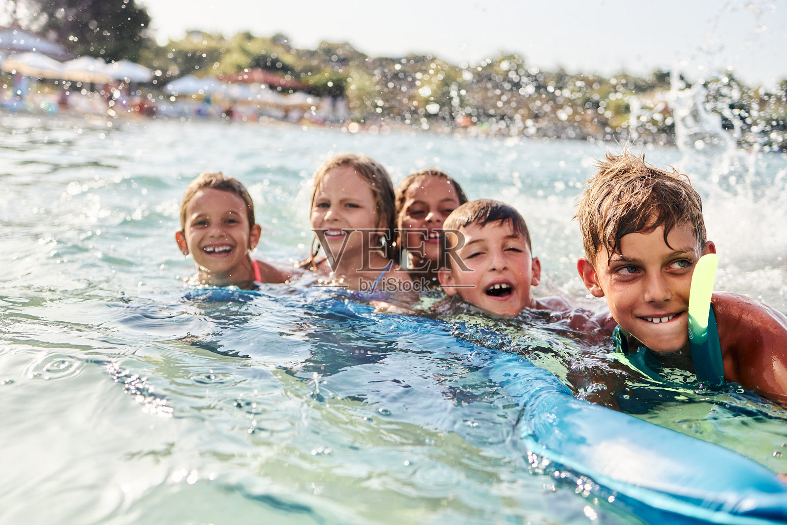快乐的孩子们在夏日假期里游泳嬉戏，溅起水花照片摄影图片
