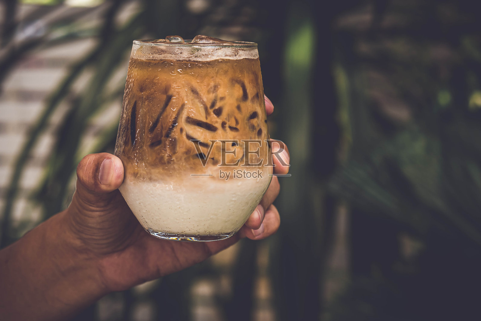 手中拿着一杯清爽的冰咖啡照片摄影图片