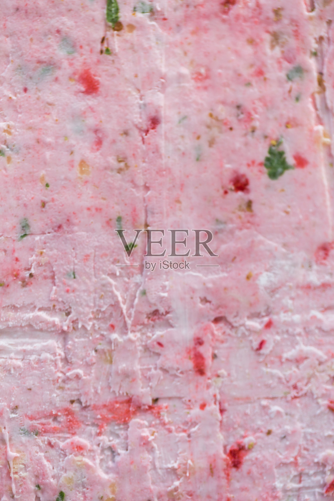 在冷冻锅上炒制冰淇淋卷。卷式冰淇淋，手工制作的冰淇淋甜点。带钢制冷冻盘的炒冰淇淋机。照片摄影图片