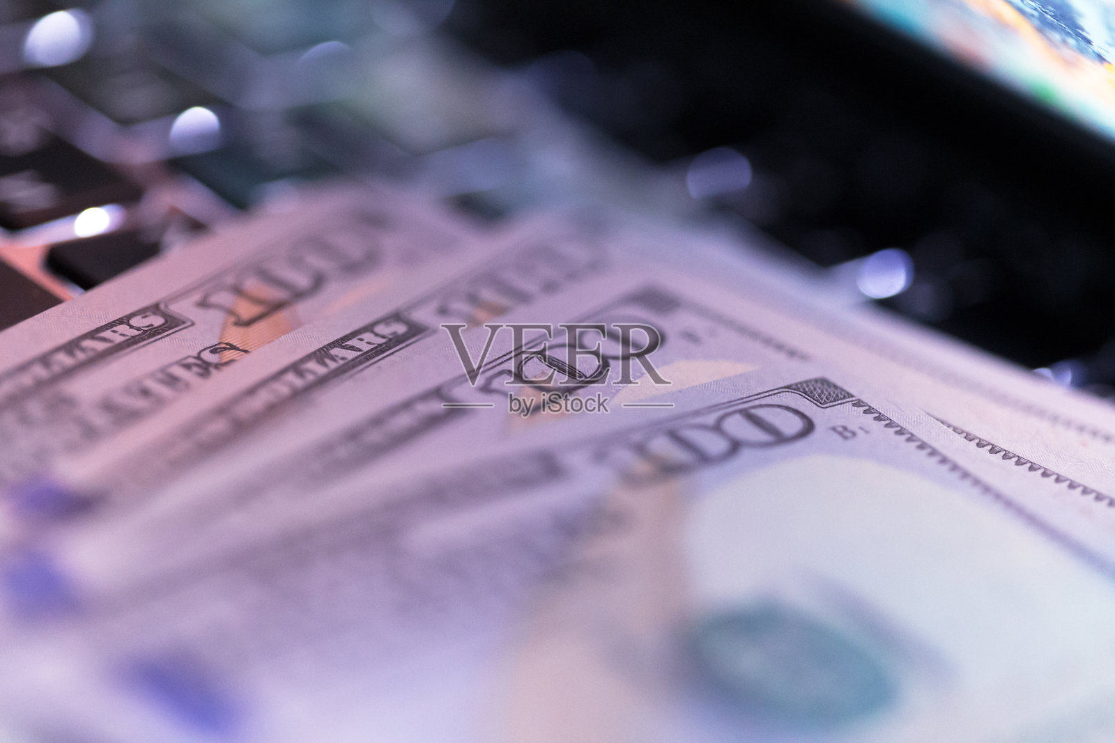 在家中金融交易场景下，笔记本键盘上放着现金照片摄影图片