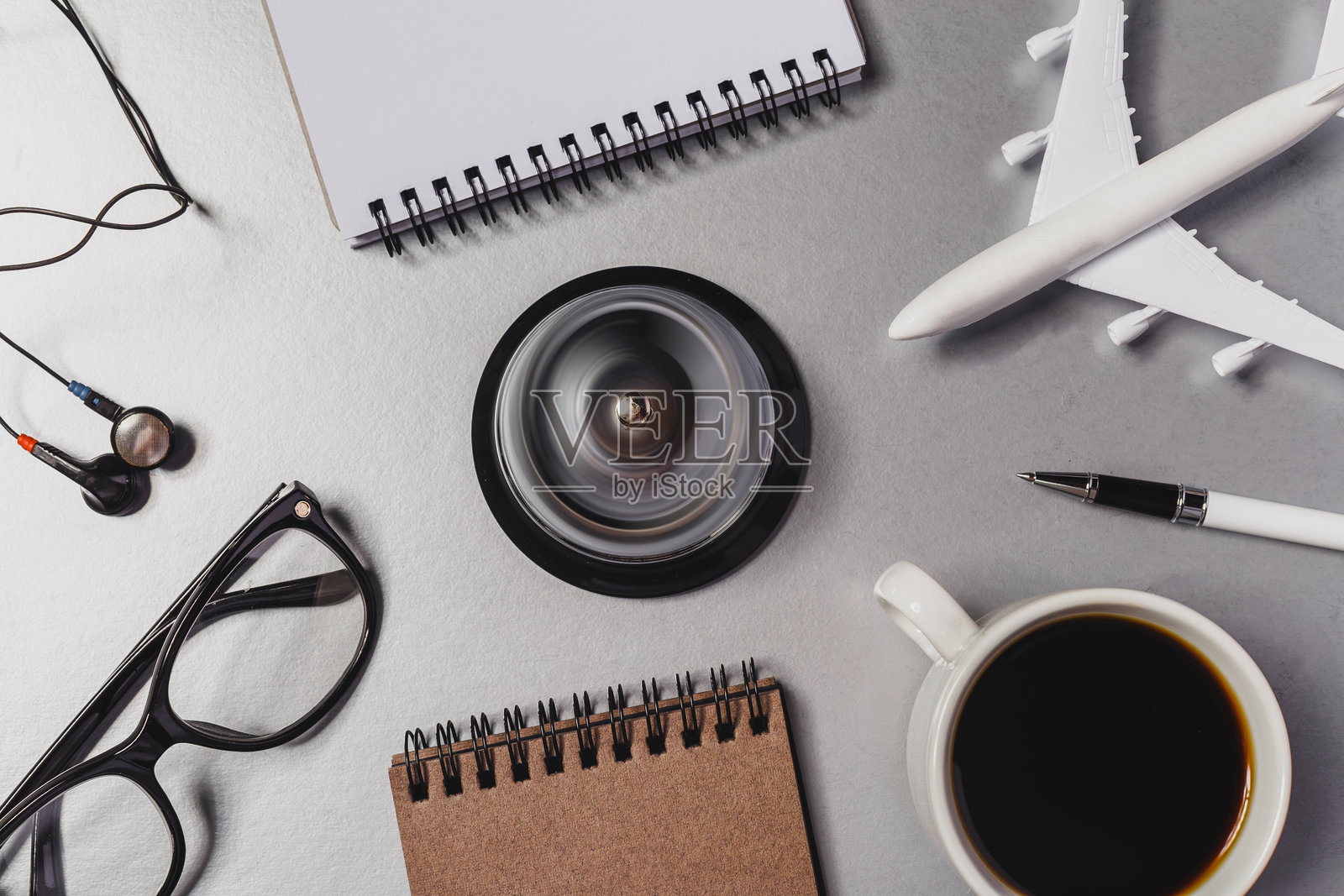 办公桌场景，有咖啡杯、笔记本、眼镜和飞机模型照片摄影图片