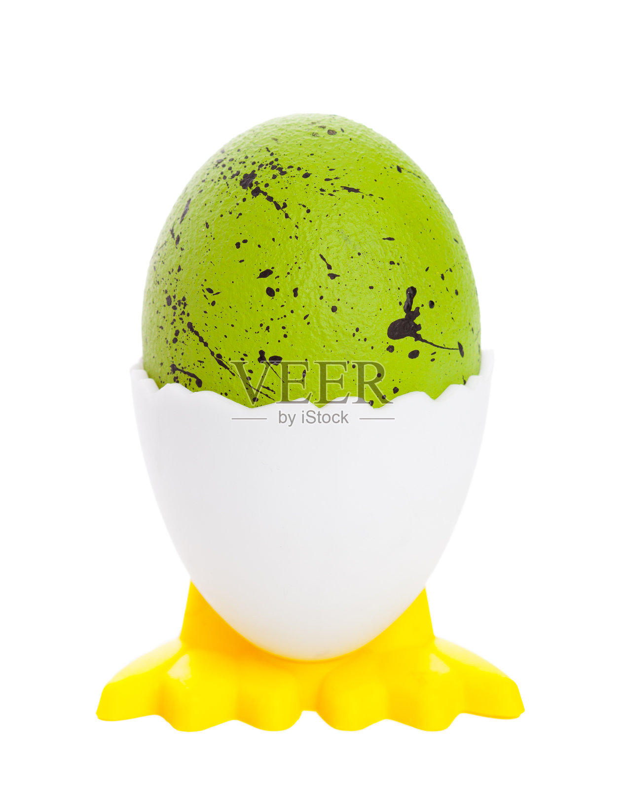 白色蛋托上放着一个亮绿色的鸡蛋，蛋托置于有泼溅颜料图案的黄色底座上。照片摄影图片