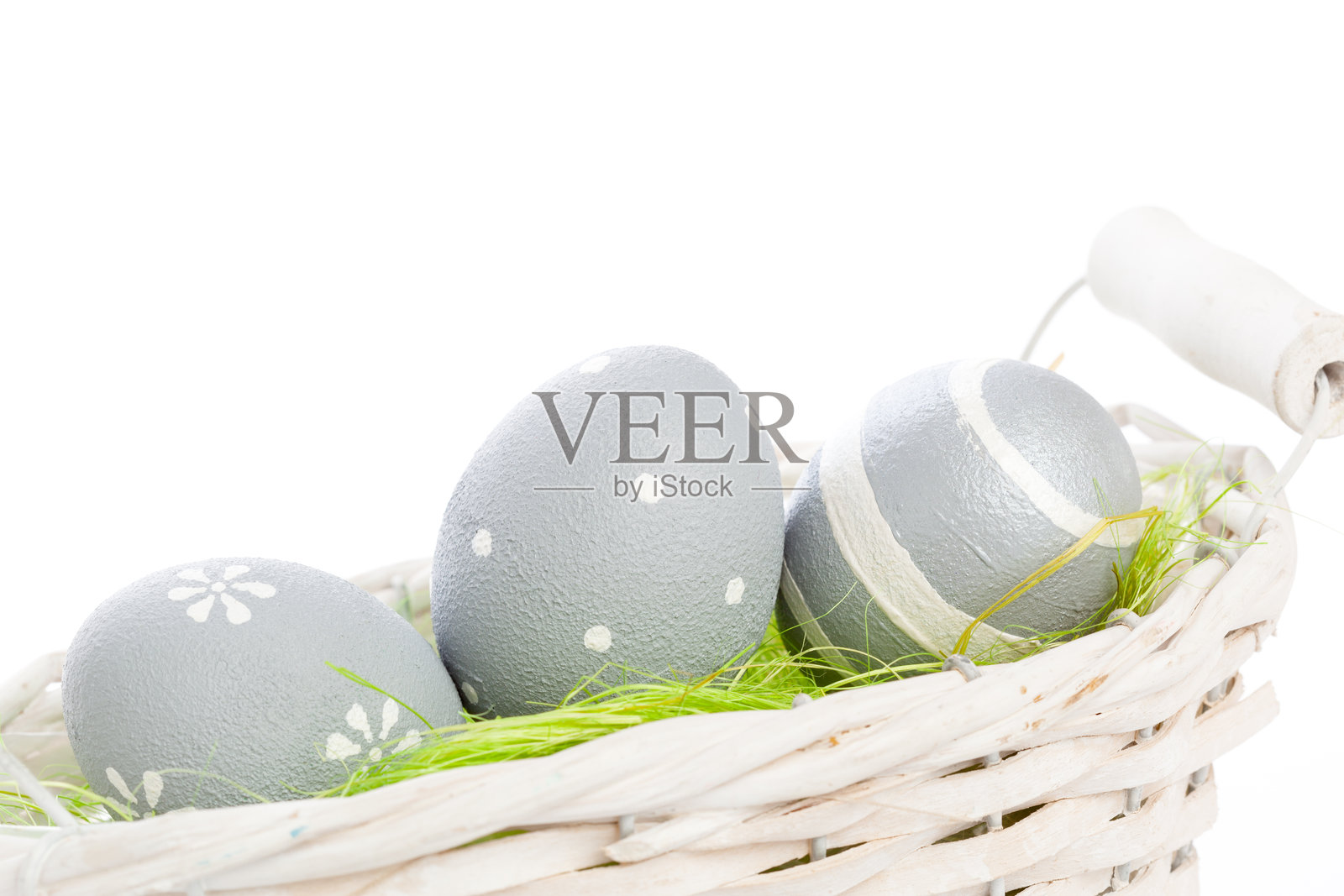 白色篮子里的装饰彩蛋，配有绿草，用于春季庆祝照片摄影图片