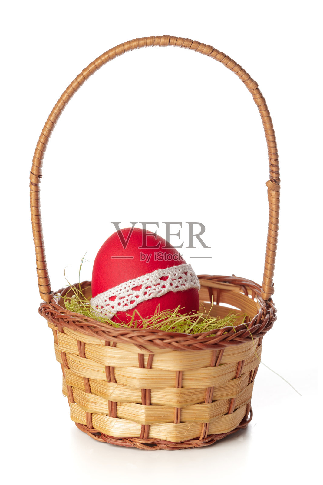 白色背景上展示着一个装有红鸡蛋和绿草的复活节篮子照片摄影图片