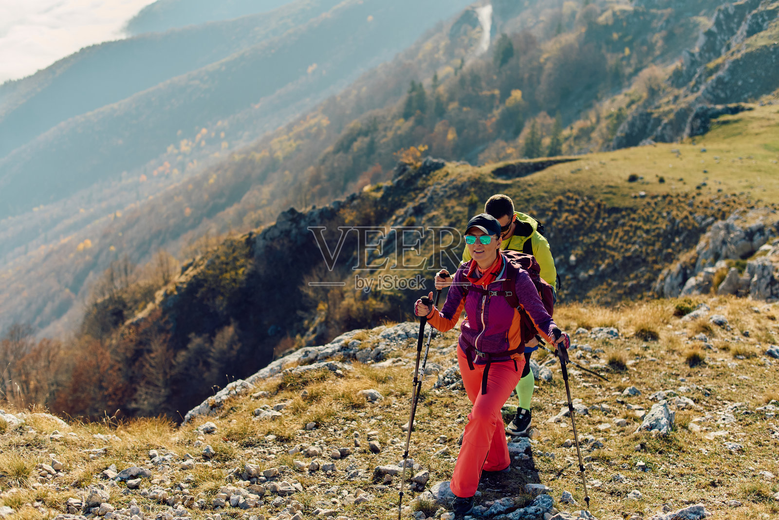 秋日晴朗，徒步者们在山间风景优美的步道上享受徒步的乐趣照片摄影图片