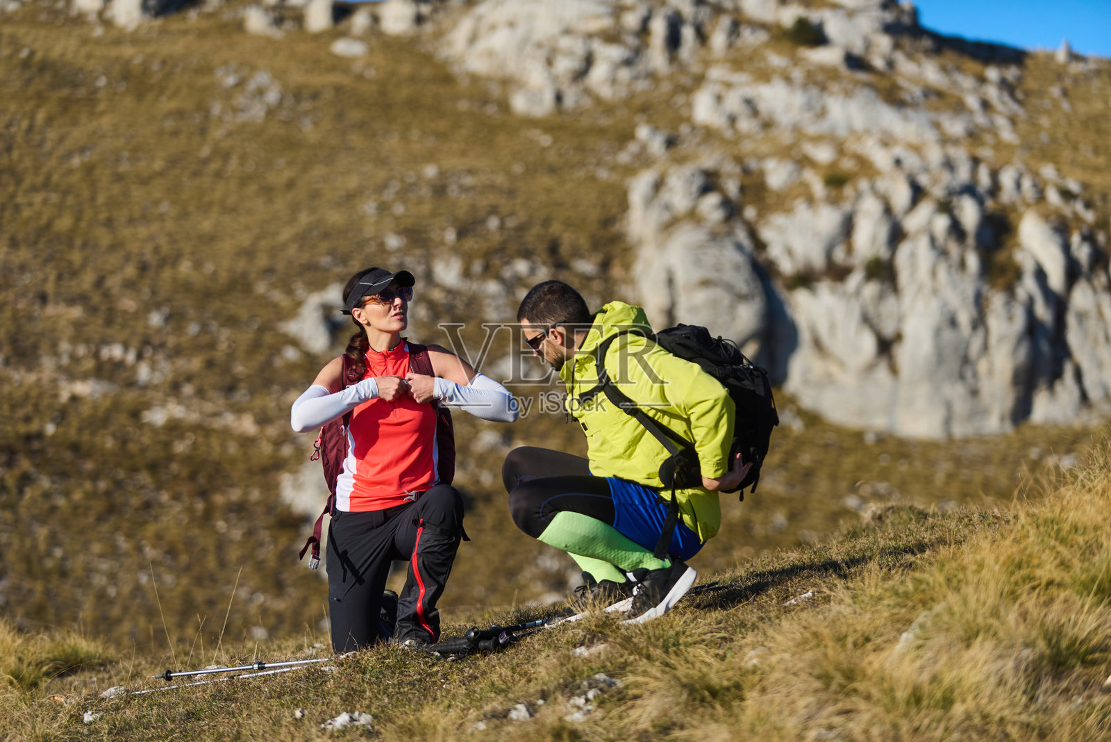 徒步情侣在蓝天下的岩石山路上休息照片摄影图片