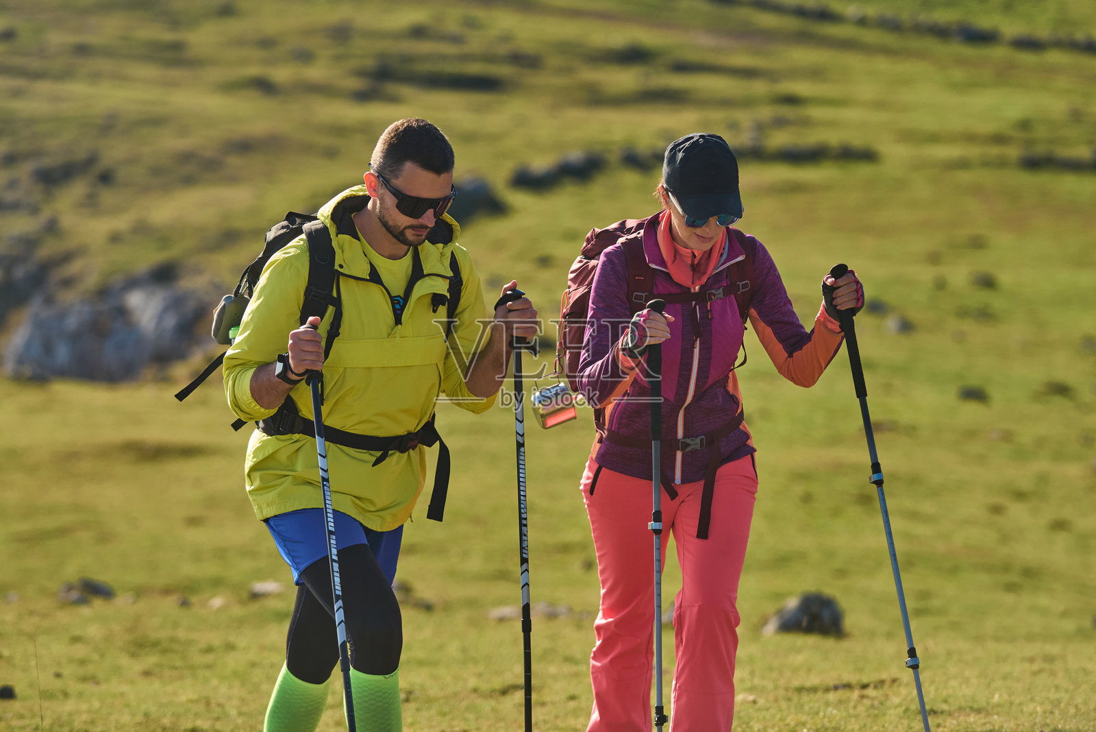 徒步者在晴朗的日子里攀登一座绿色的小山，在风景优美的自然景观中享受探险之旅。照片摄影图片