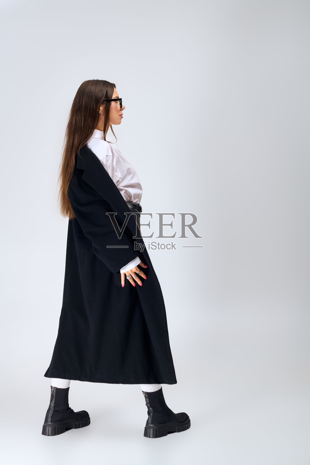 时尚的年轻女子在灰色影棚环境中展示她的外套照片摄影图片