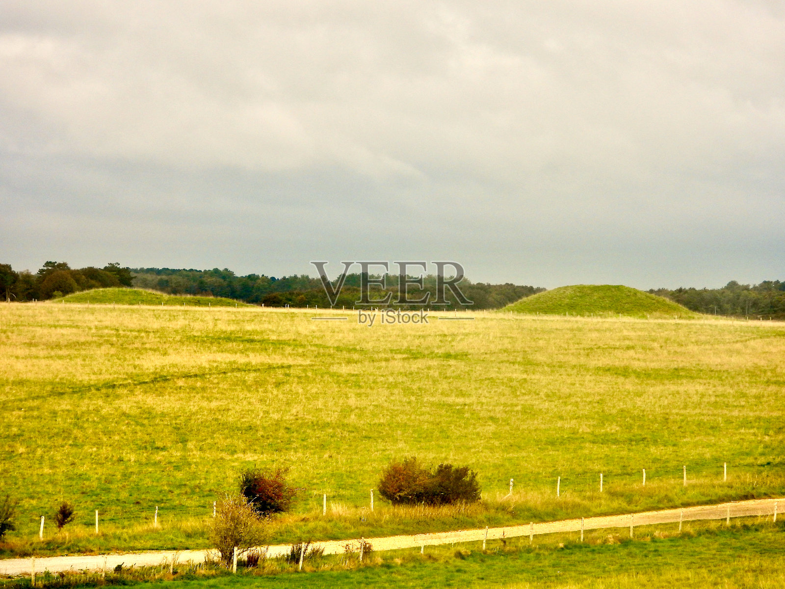 多云天气下的巨石阵墓葬土丘照片摄影图片