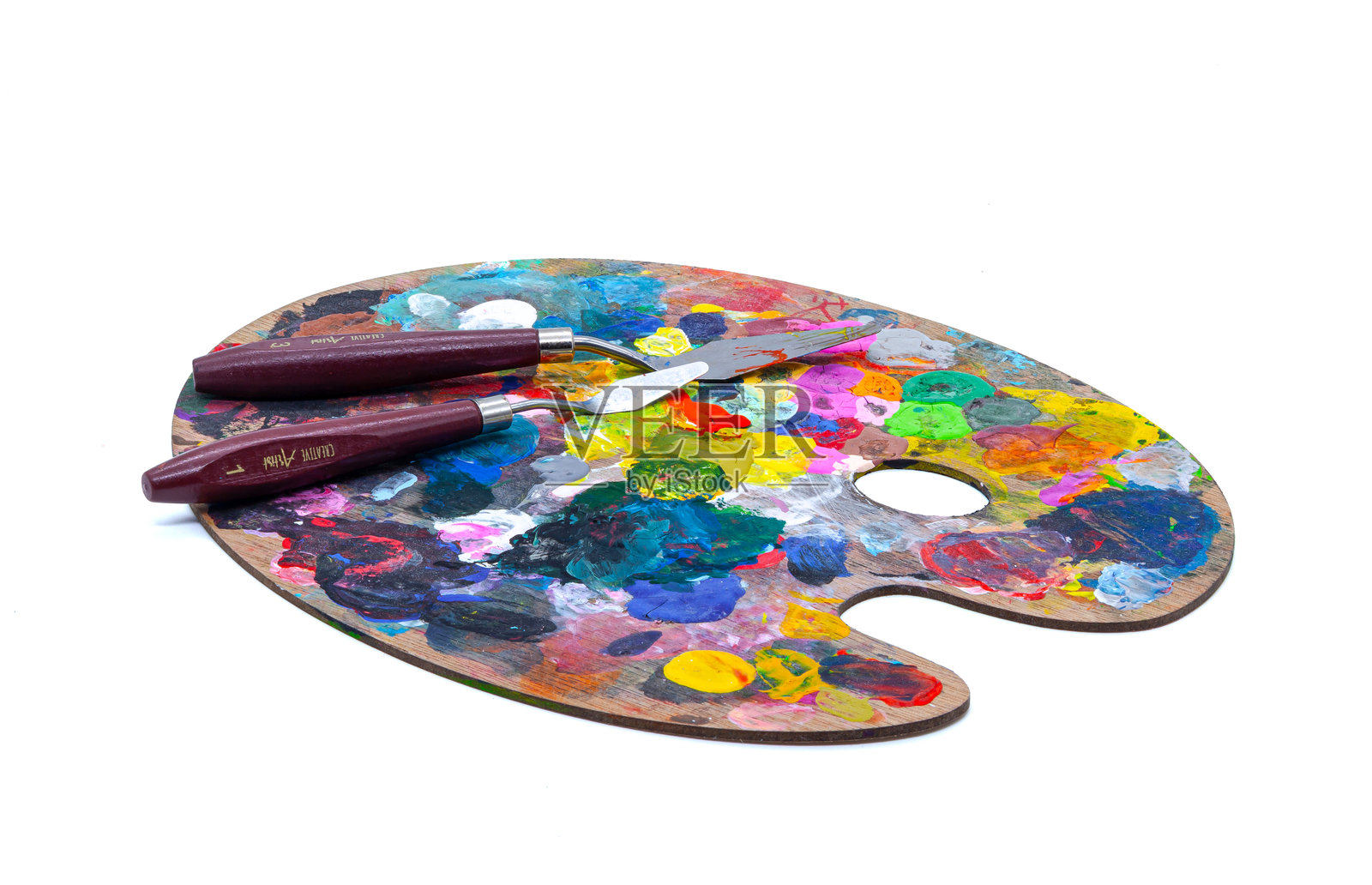 白底孤立的木质调色板，上面有鲜艳的油画颜料和调色刀照片摄影图片